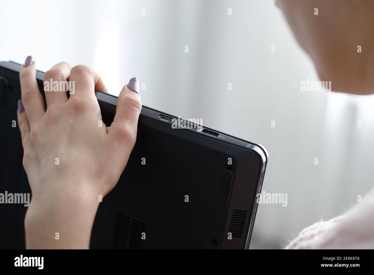 donna che cerca le interfacce del computer portatile. chiudi le porte usb e la porta video hdmi. controlla il computer portatile Foto Stock