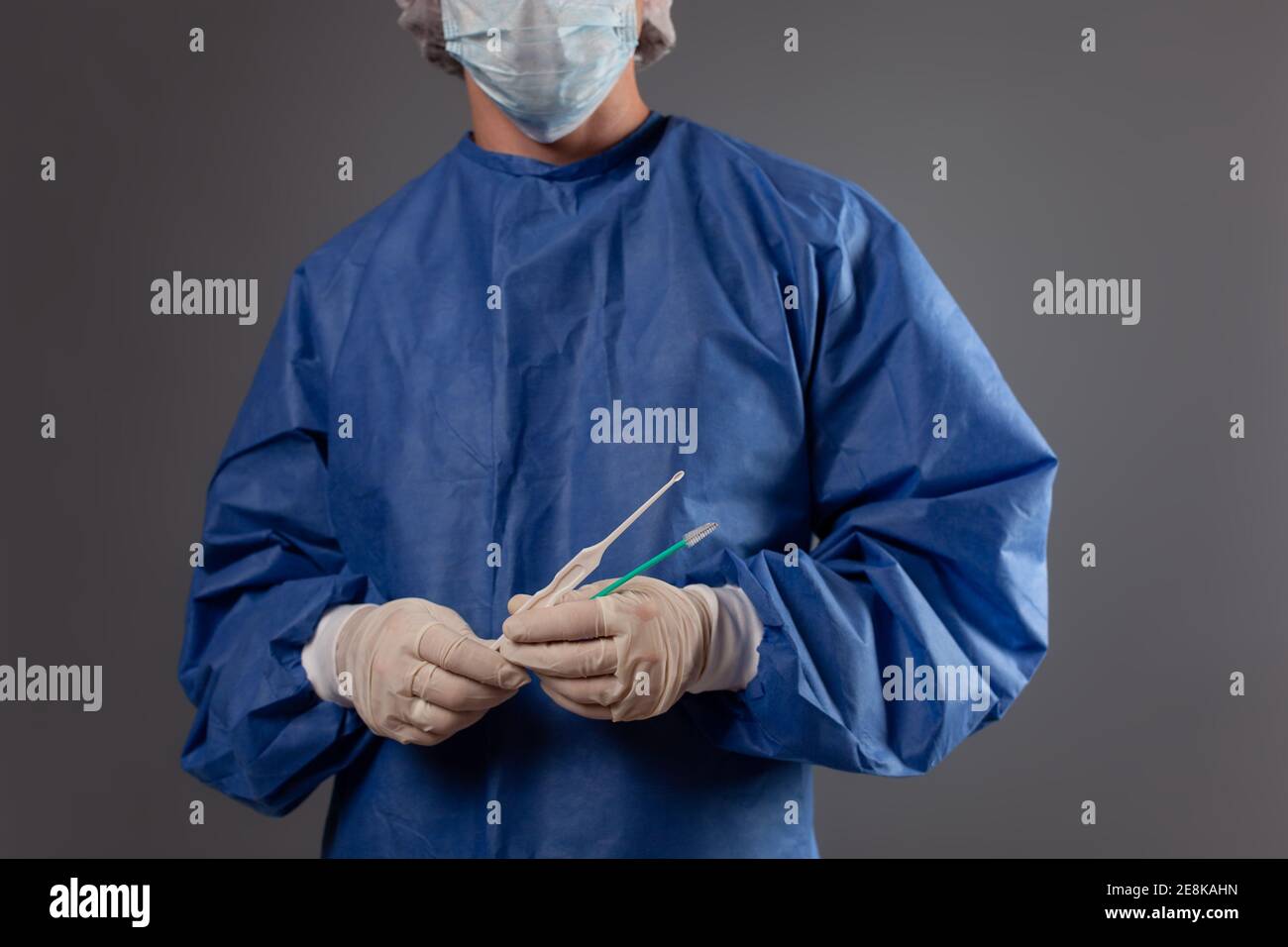 Un ginecologo con uno specchio venere nelle mani. Accessori ginecologici,  spazzola, bastone. Un medico in una maschera medica, un accappatoio, guanti,  un cappello con un gyn Foto stock - Alamy