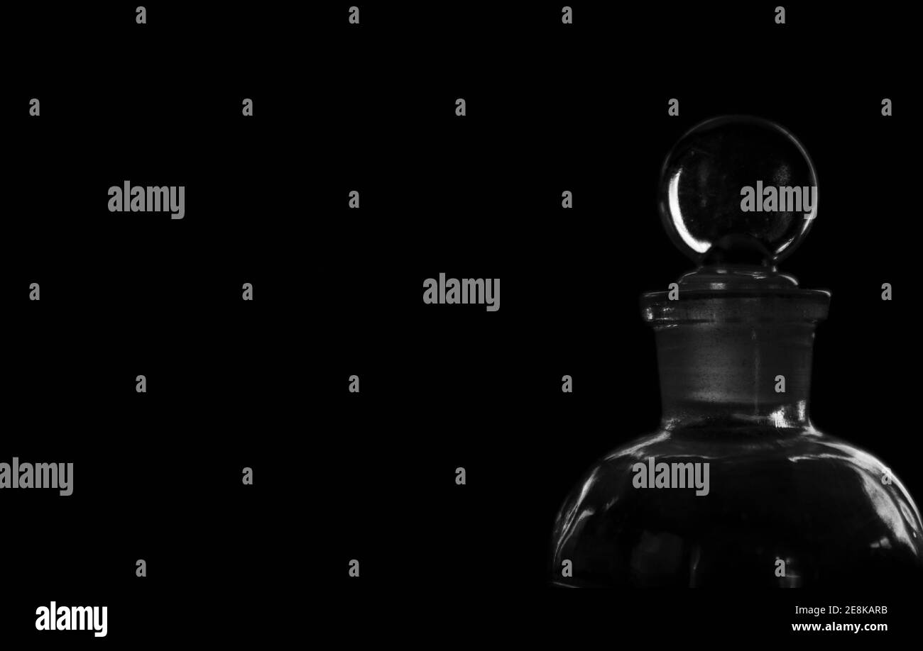 Fiala in vetro antico con tappo rotondo su sfondo nero con evidenziazioni chiare e nitide e spazio negativo per la copia Foto Stock