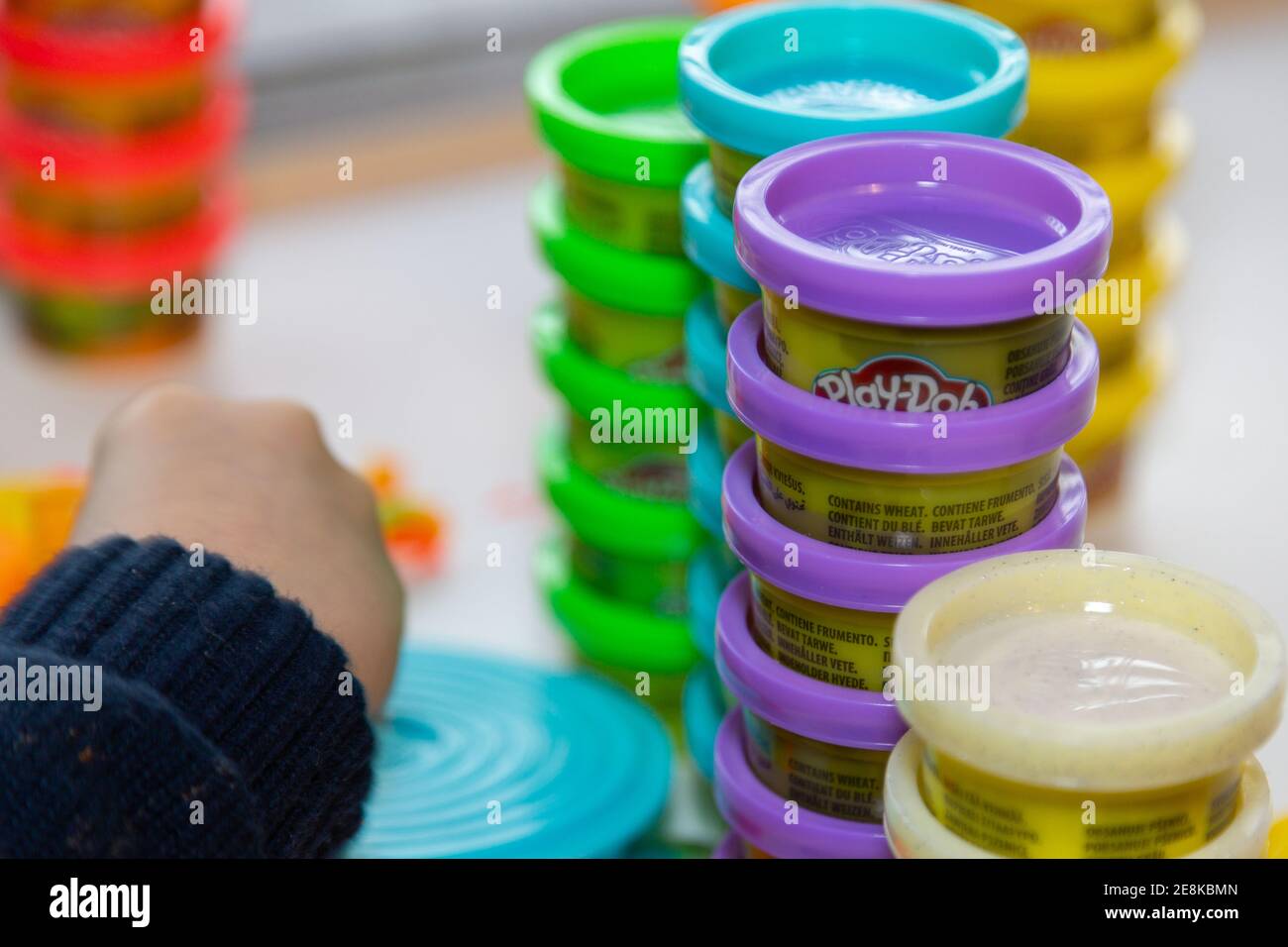 Un bambino che gioca con Play Doh modellando l'argilla a un tabella Foto Stock