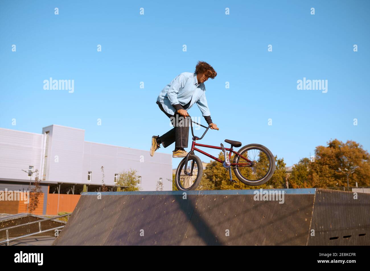 BMX biker che fa trucco sulla rampa in skatepark Foto Stock