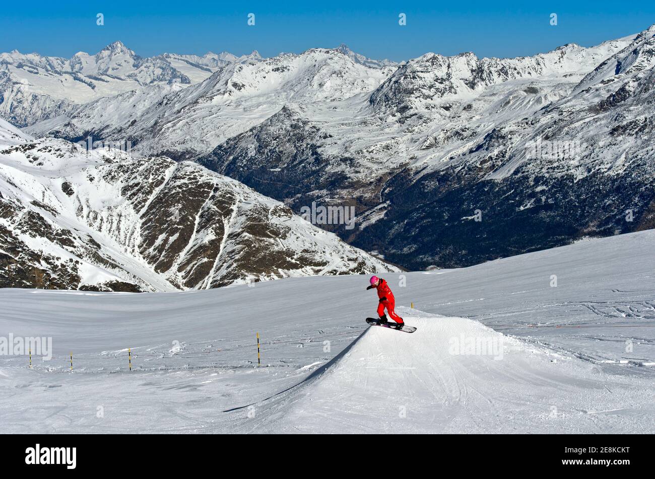 Snowboarder su una collina di salto nella zona sciistica di Saas-Fee, Vallese, Svizzera Foto Stock