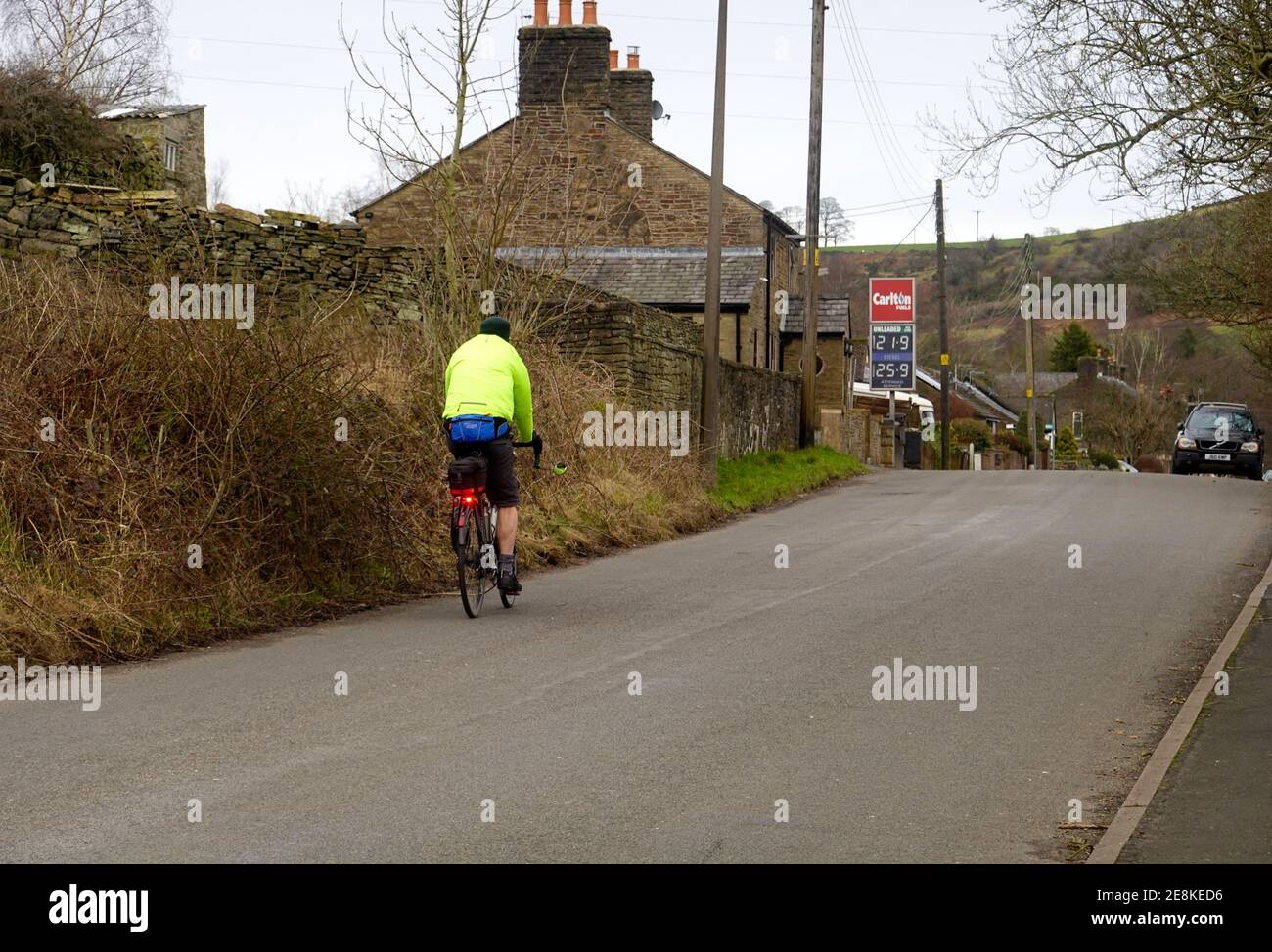 Un ciclista che indossa una giacca ad alta visibilità a Thornsett, Derbyshire/ Foto Stock
