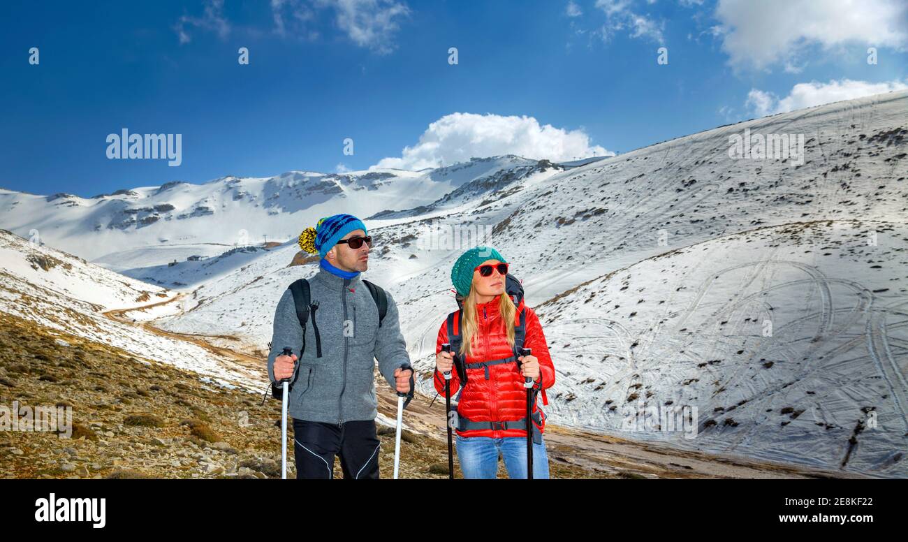 Bella coppia arrampicarsi sulla montagna con Trekking Poles. Goditi la vista incredibile. Buone Vacanze invernali attive. Zest per la vita. Foto Stock