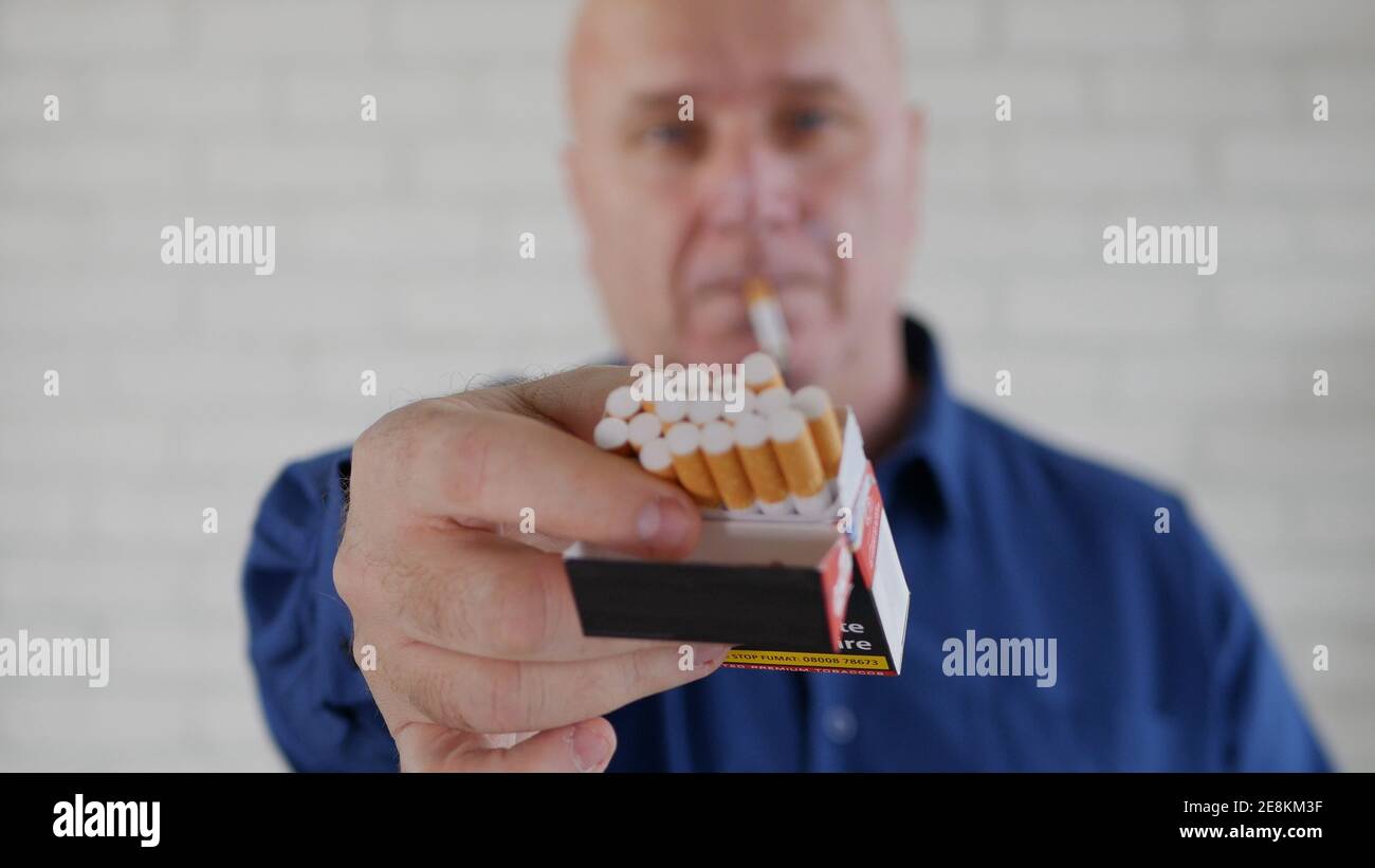 Immagine con un uomo d'affari che fuma una sigaretta. L'aggiunta di fumo e nicotina causa gravi problemi di salute. Foto Stock