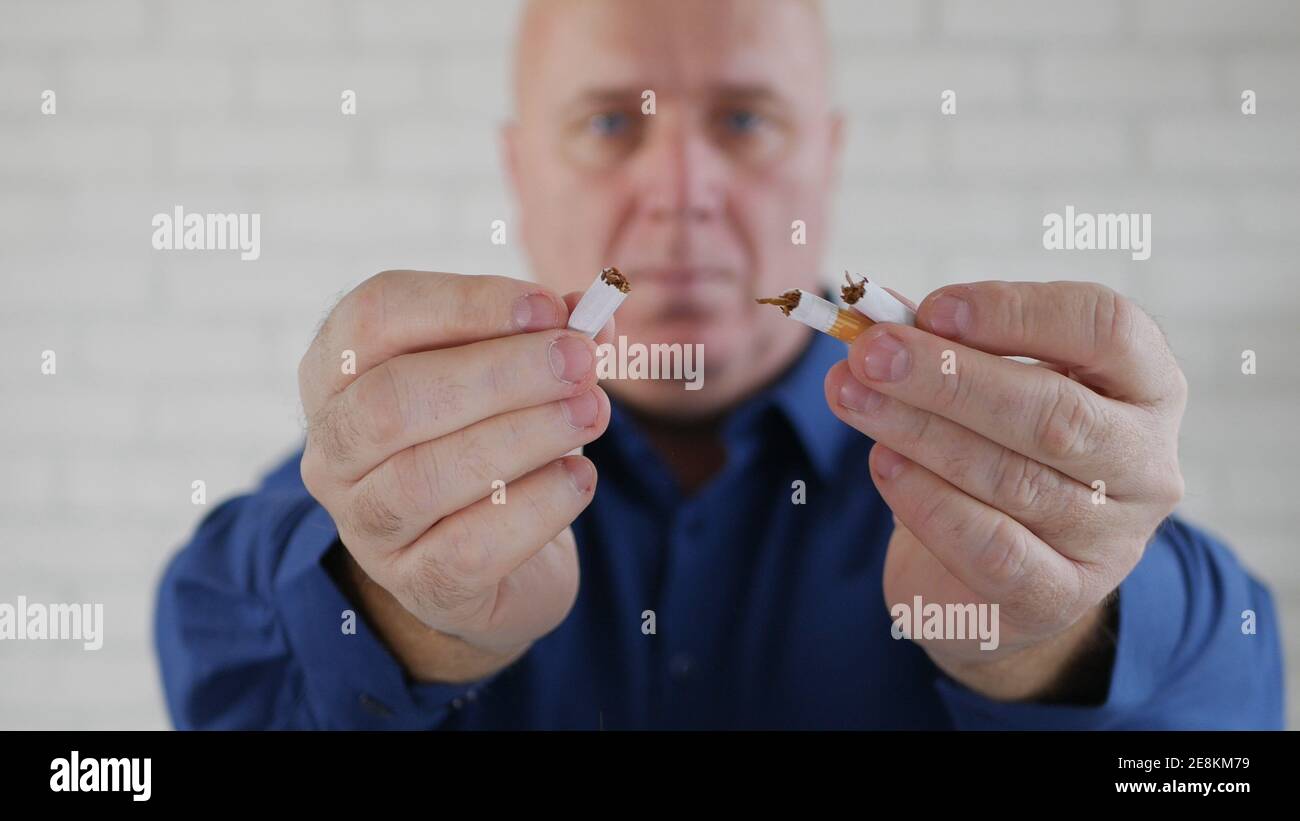 Immagine con un uomo d'affari che fuma una sigaretta. L'aggiunta di fumo e nicotina causa gravi problemi di salute. Foto Stock