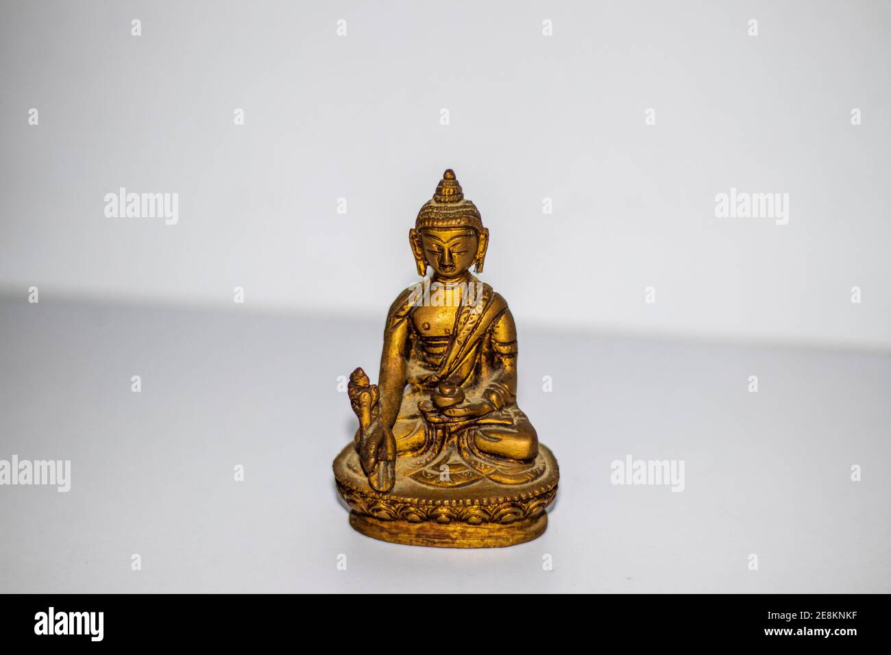 Primo piano di una mini statua in bronzo del buddha. Foto Stock