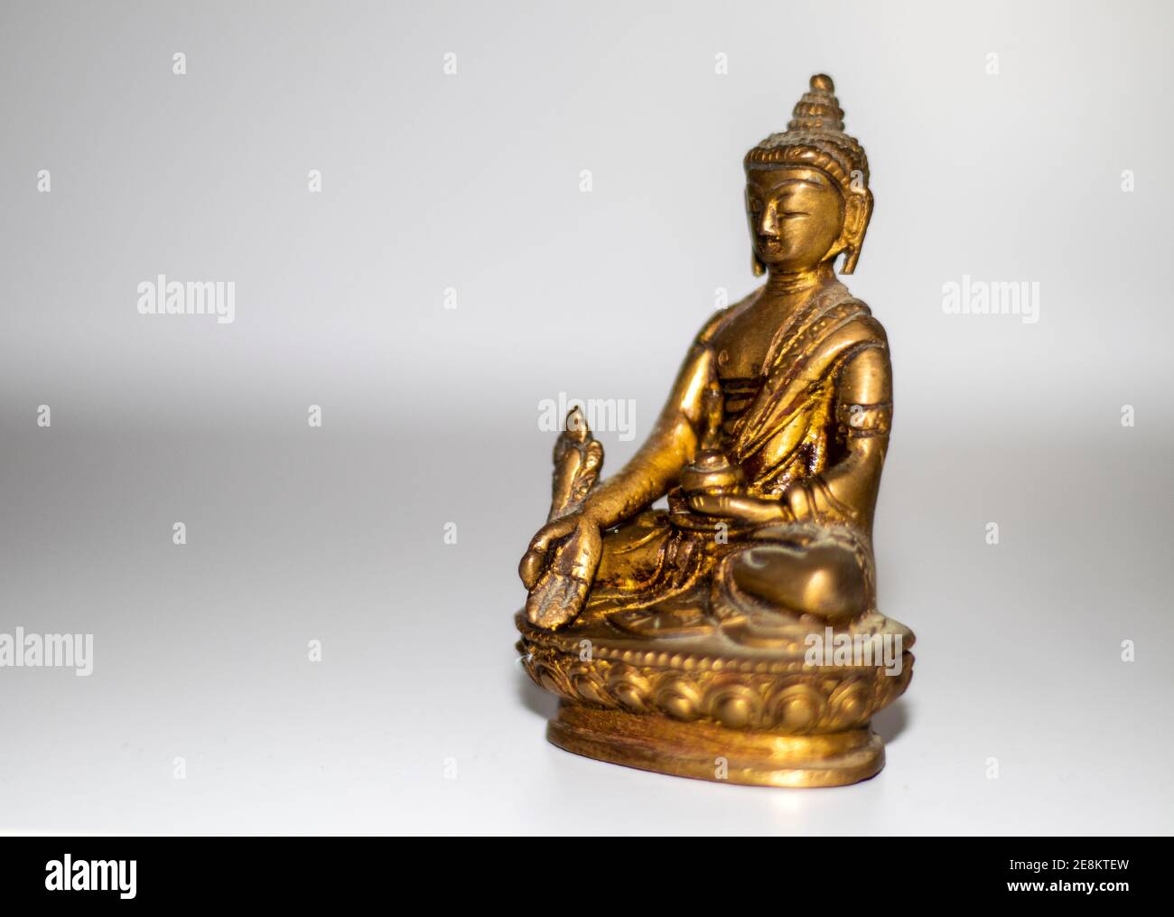 Primo piano di una mini statua in bronzo del buddha. Foto Stock