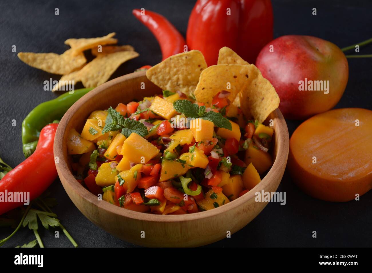 Salsa con mango, erbe, cipolle e peperoni, patatine di mais da vicino in una ciotola. Cibo messicano. Foto Stock