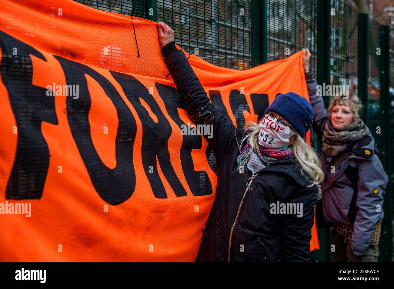 Londra, Regno Unito. 31 gennaio 2021. I sostenitori arrivano con un banner che recita "Stop HS2 Now, BattleforEuston" - il campo di ribellione anti-estinzione HS2 continua ad essere sgomberato (per creare un'area di parcheggio temporanea) dai Bailiffs (del National Enforcement Team, NET, una filiale di High Court Enforcement Group) presso la stazione di Euston. Tutti i manifestanti di terra sopra sono stati eliminati e sembra che ora ci sia una pausa prima che le gallerie siano trattate. Credit: Guy Bell/Alamy Live News Foto Stock