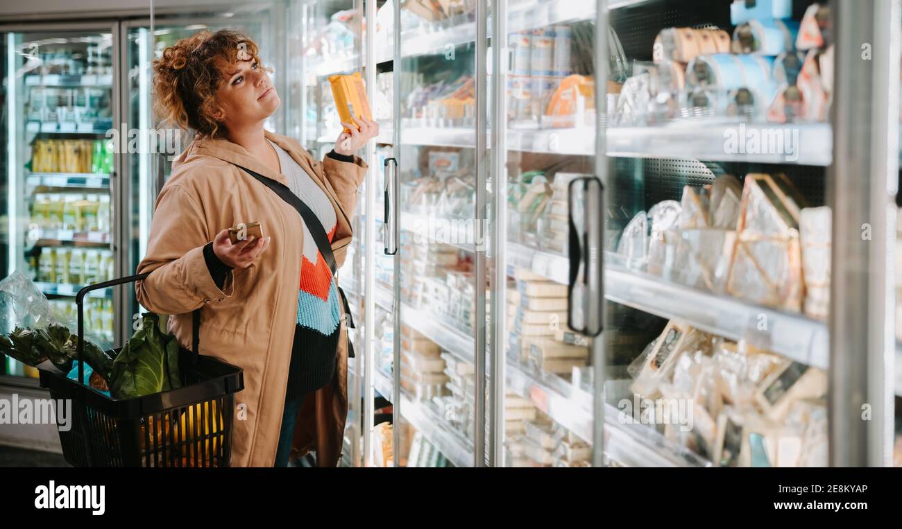 Donna che acquista generi alimentari da un supermercato. Donna cliente shopping in supermercato. Foto Stock