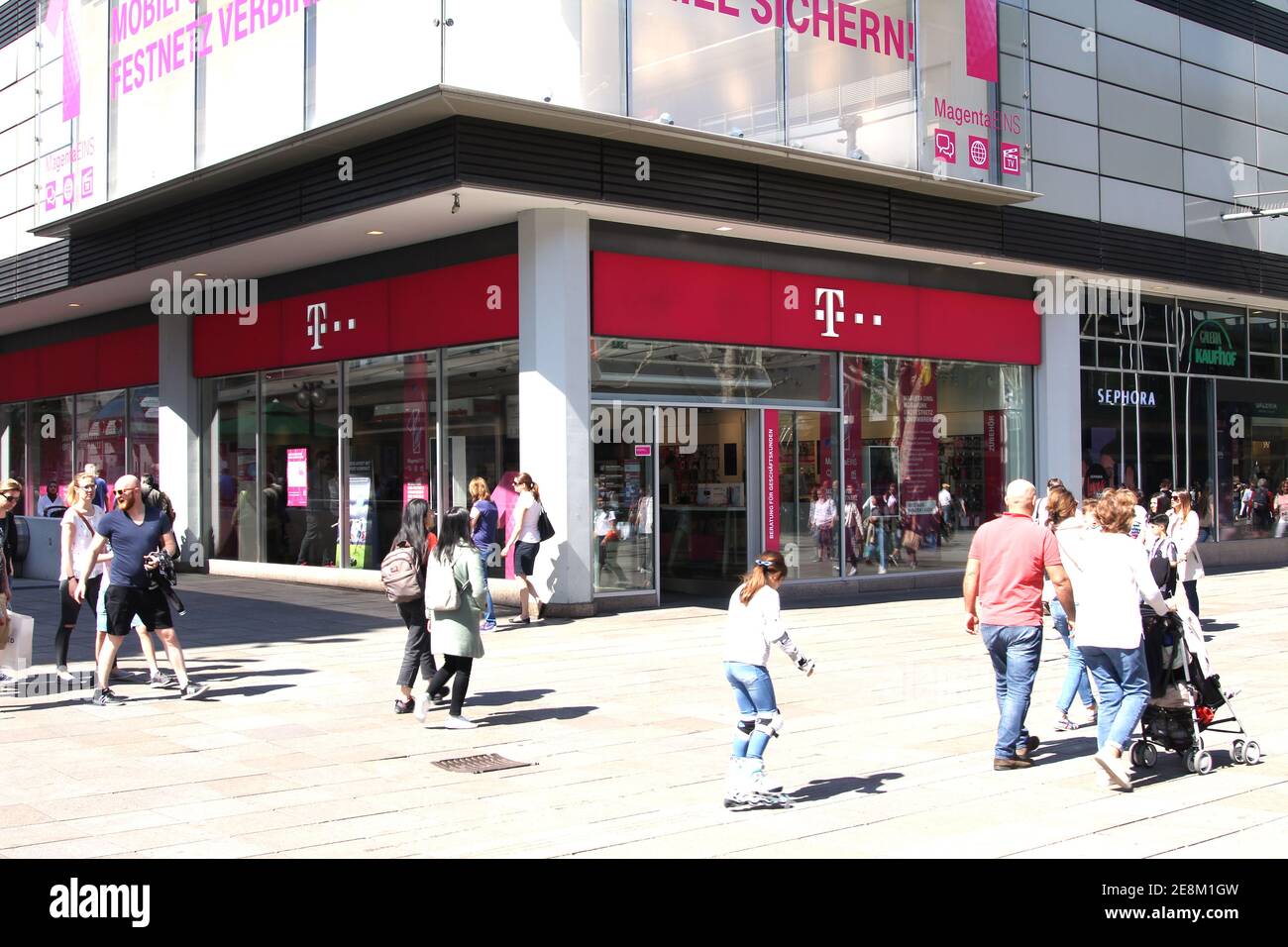 Negozio T-Mobile con persone. T-Mobile è il marchio utilizzato dalle filiali di comunicazioni mobili della società tedesca di telecomunicazioni Foto Stock