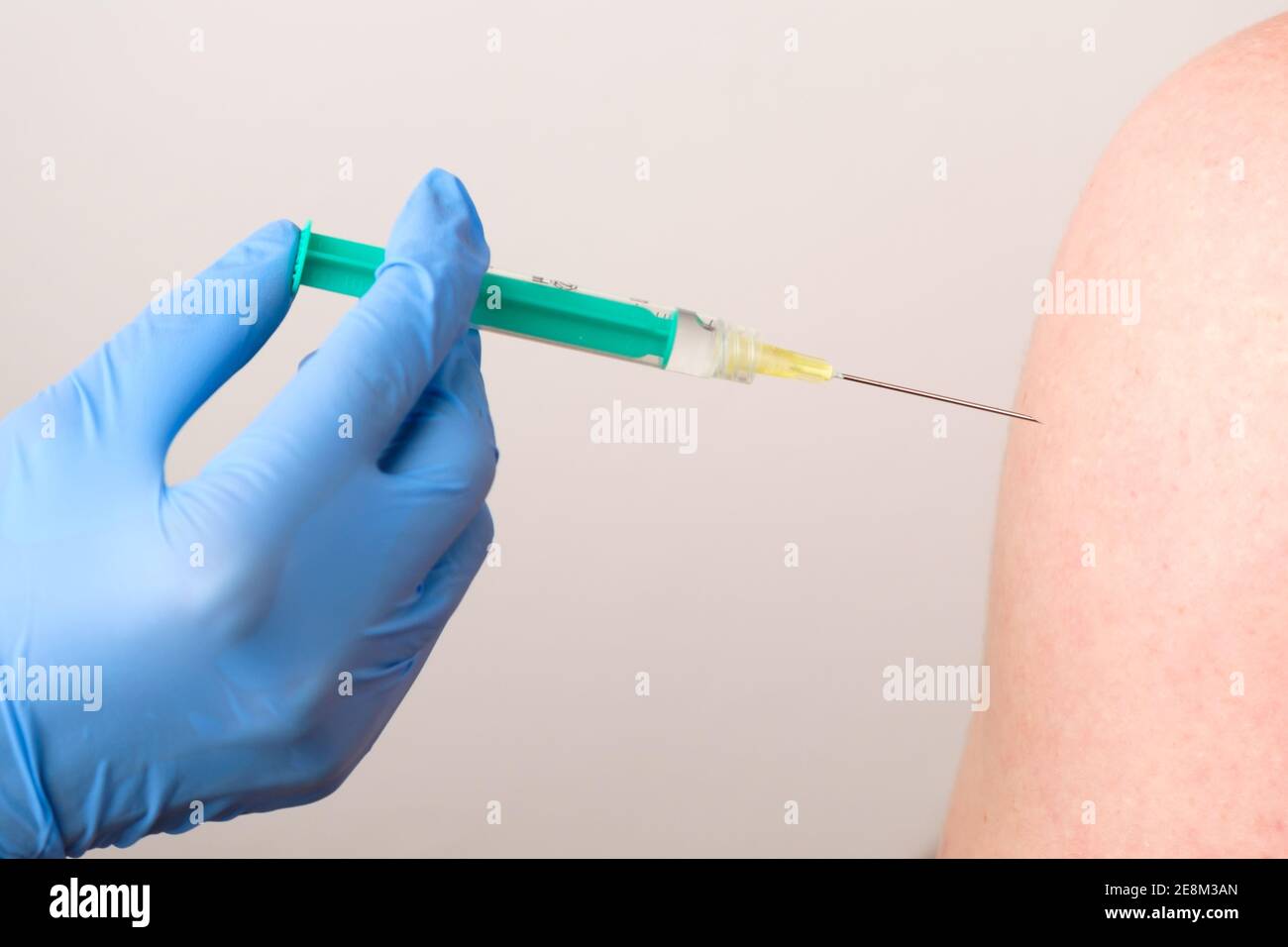 Un medico o un infermiere in guanti di gomma dà un colpo o un'iniezione. Vaccinazione contro il coronavirus, SARS-Cov-2. Foto Stock