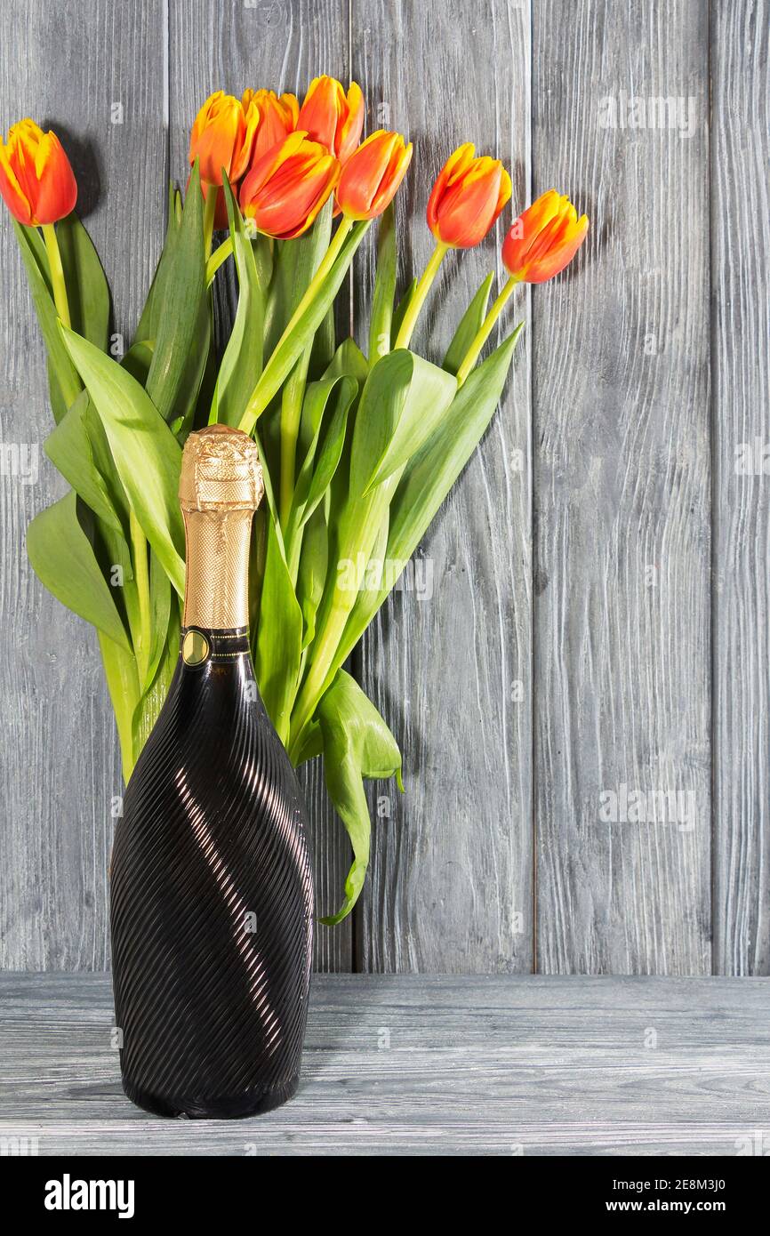 Una bottiglia di champagne e fiori di tulipano. La vacanza è l'8 marzo,  festa della mamma. Ambiente romantico Foto stock - Alamy