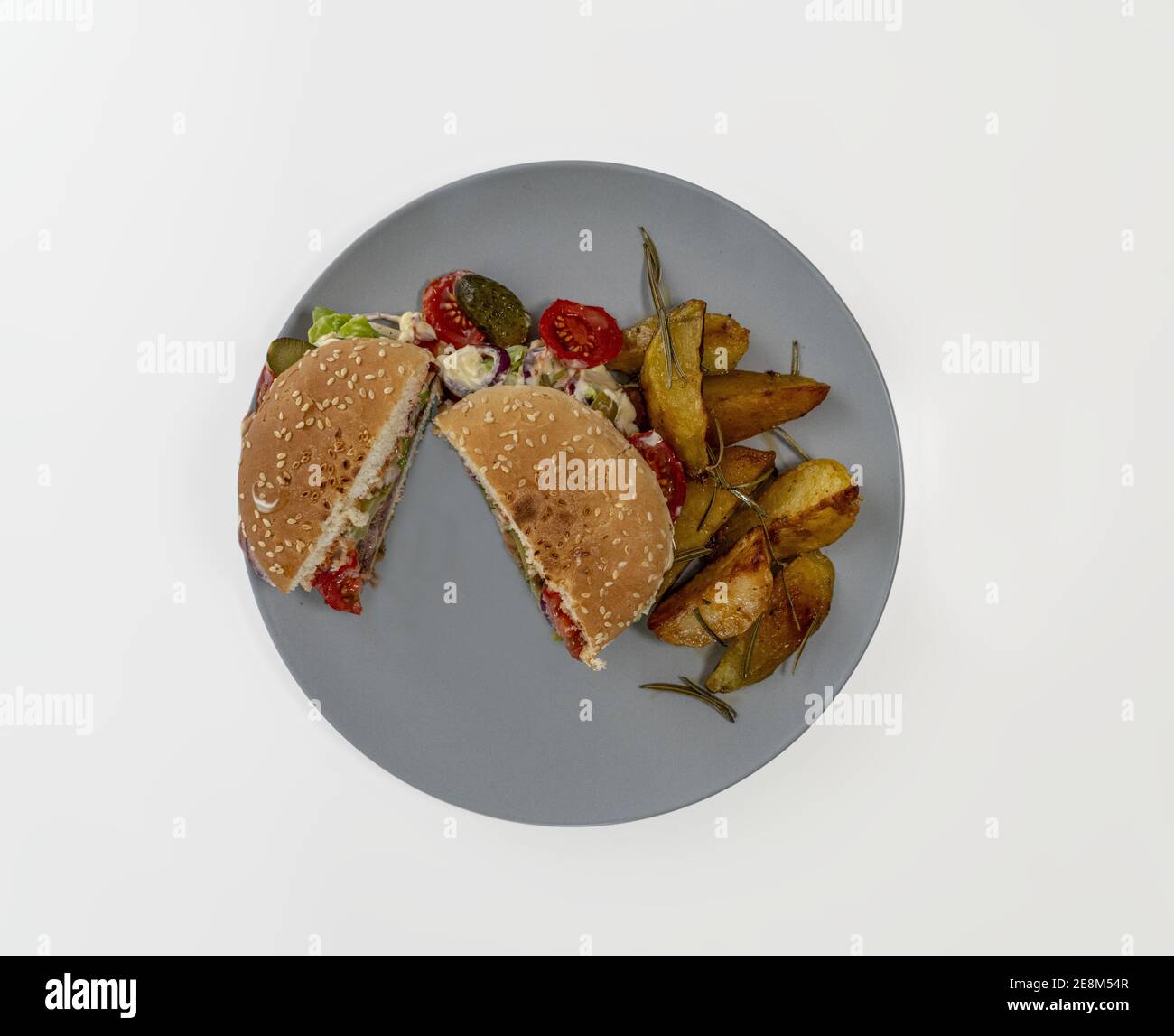 Una vista dall'alto di un hamburger servito in due metà con patate fritte Foto Stock