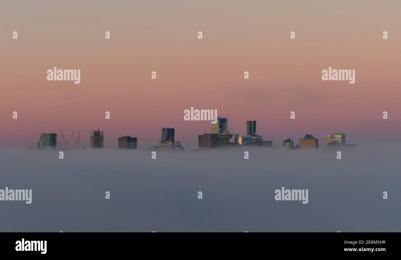 Città tra le nuvole, Paradise City, City of Angels, Vancouver City grattacieli sopra la nebbia con il sole del mattino che creano un falso tramonto riflettente Foto Stock