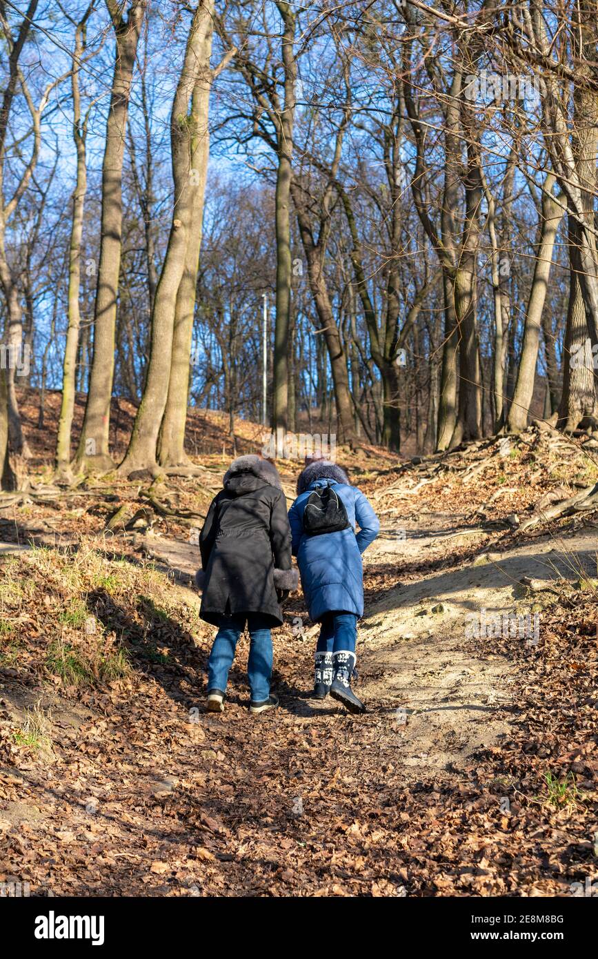 Due ragazze vanno in salita. Donna trekking attraverso boschi verdi vegetazione, in salita. Turismo e concetto di viaggio Foto Stock