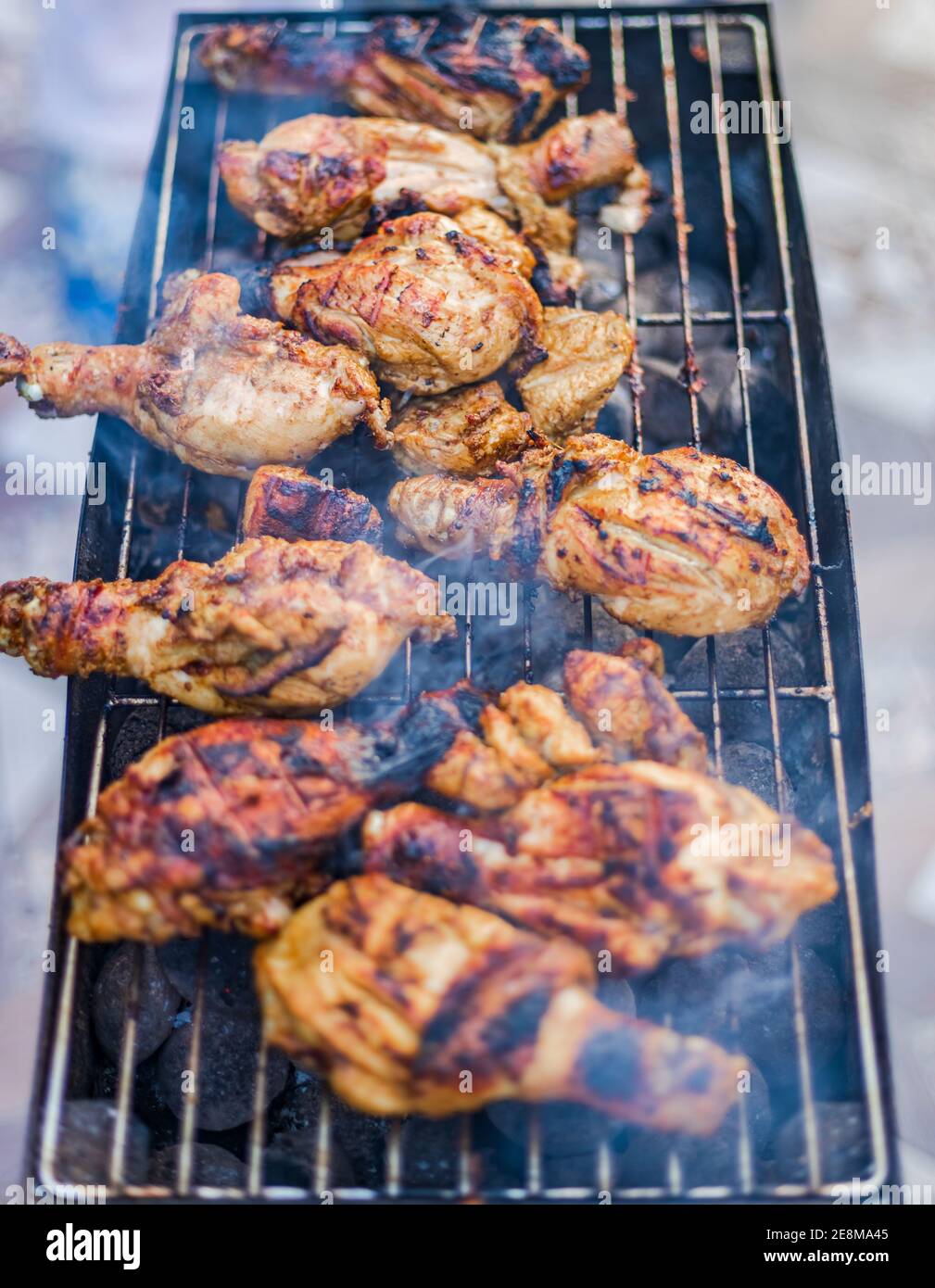 Preparazione del delizioso barbecue grigliato affumicato sulla fiamma di carbone all'aperto. Foto Stock