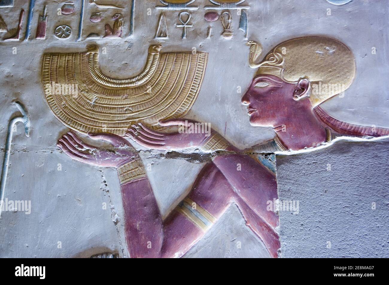 Antica scultura in bassorilievo egiziano che mostra il faraone Seti i tenendo una collana in stile colletto d'oro. Tempio di Abydos, El Balyana, Egitto. Scultura antica Foto Stock