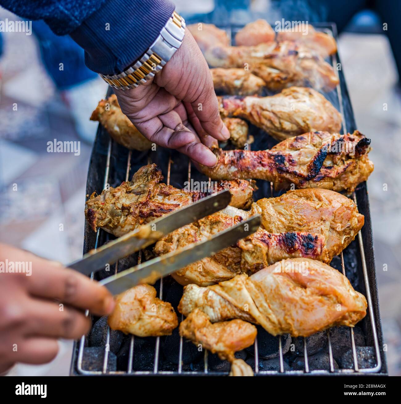 Preparazione del delizioso barbecue grigliato affumicato sulla fiamma di carbone all'aperto. Foto Stock