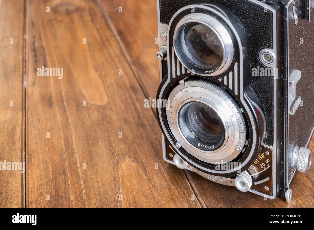 dettaglio degli obiettivi di una fotocamera reflex a doppia lente d'epoca, su un tavolo di legno, fotografia antica e classica, copy space, orizzontale Foto Stock