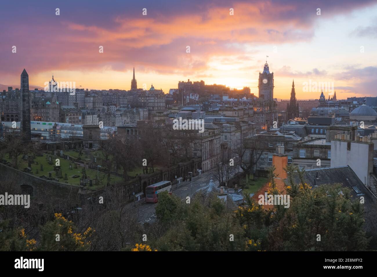 Vista panoramica dello skyline della città vecchia di Edimburgo, Princes Street, la Torre dell'orologio Balmoral e il Castello di Edimburgo dalla collina di Calton con un tramonto spettacolare nella Foto Stock
