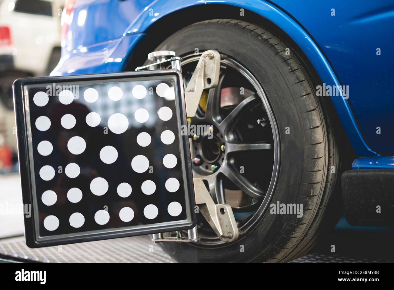 un'auto in servizio con sensori sulle ruote da a. controllare la convergenza della campanatura dell'allineamento Foto Stock