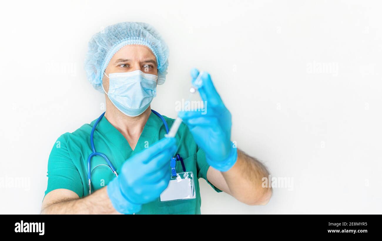 Concetto di vaccinazione con coronavirus di Covid-19. Il medico tiene una siringa nelle mani e si prepara ad iniettare il paziente. Studi sul vaccino del coronavirus. PROV Foto Stock