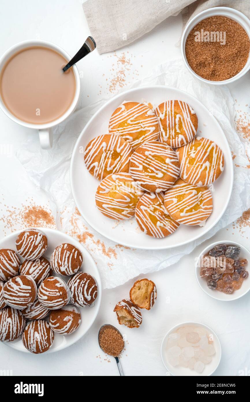 Dessert di due tipi di biscotti, zucchero di canna e una tazza di caffè su sfondo bianco. Foto Stock