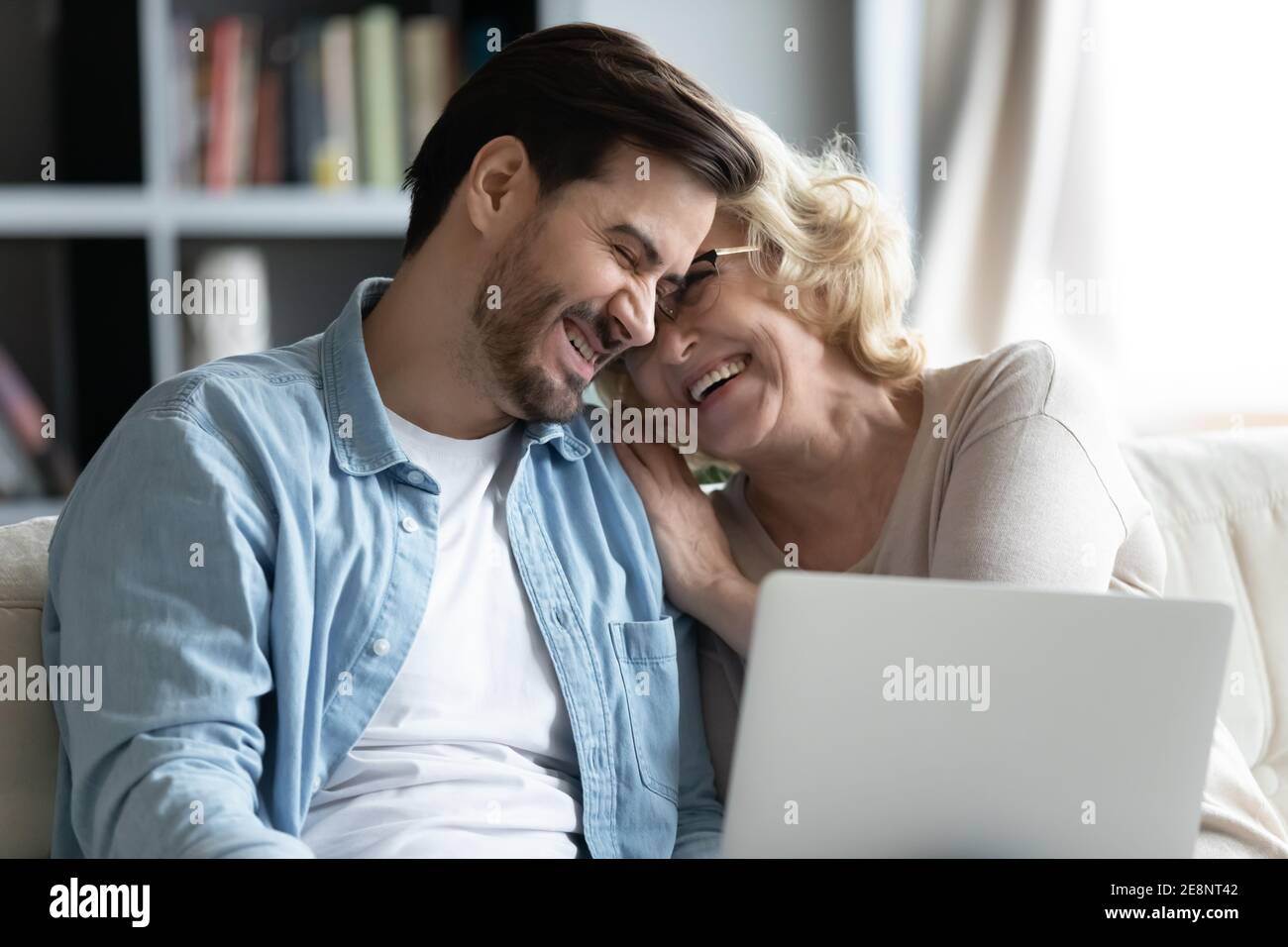 Bonding famiglia felice di due generazioni ridendo, guardando divertente video online. Foto Stock