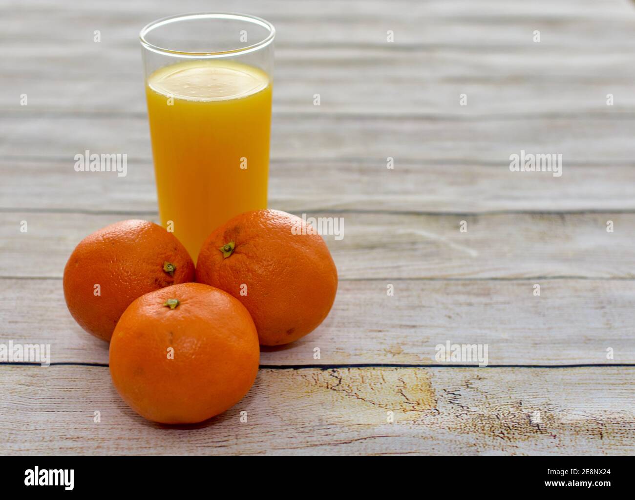 Fresco spremuto sano succo d'arancia e intere arance ombelico primo piano sfondo, concetto foto vita sana, spazio copia Foto Stock