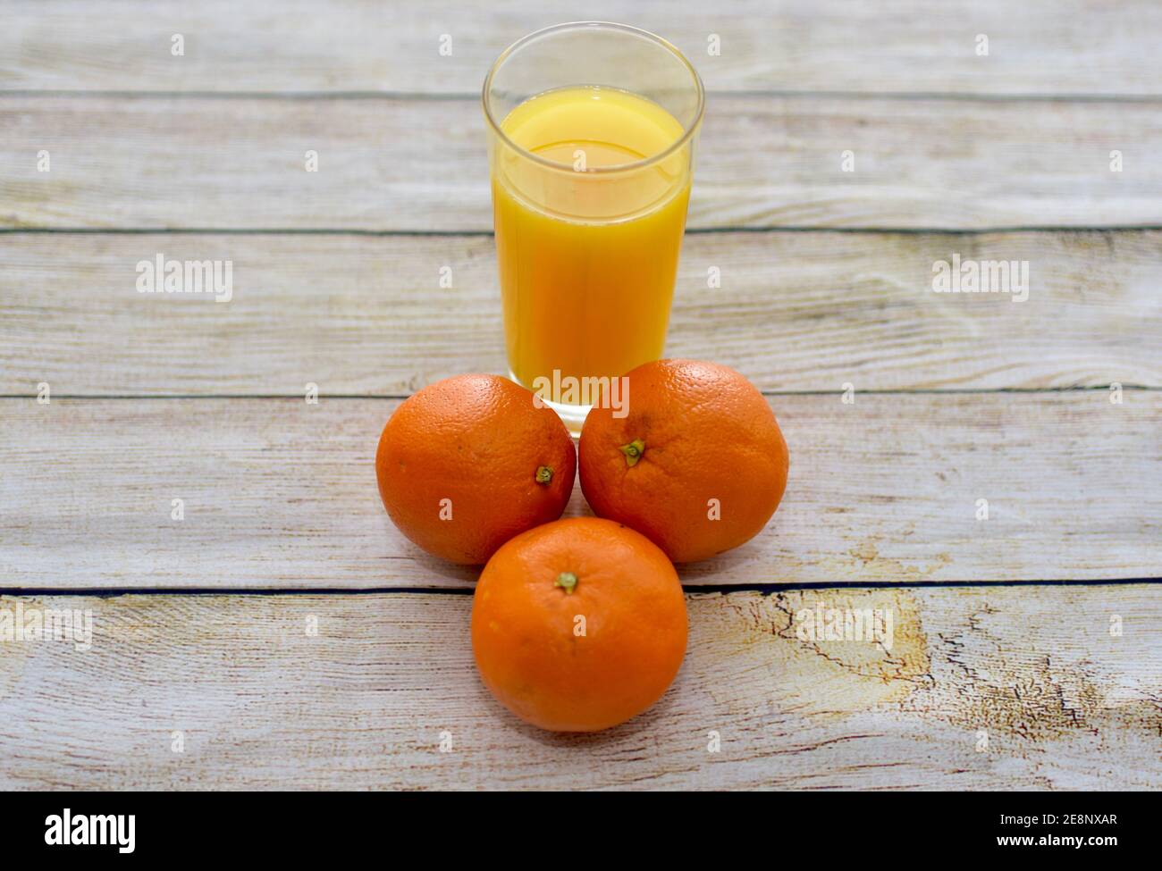 Fresco spremuto sano succo d'arancia e intere arance ombelico primo piano sfondo, concetto foto vita sana, spazio copia Foto Stock