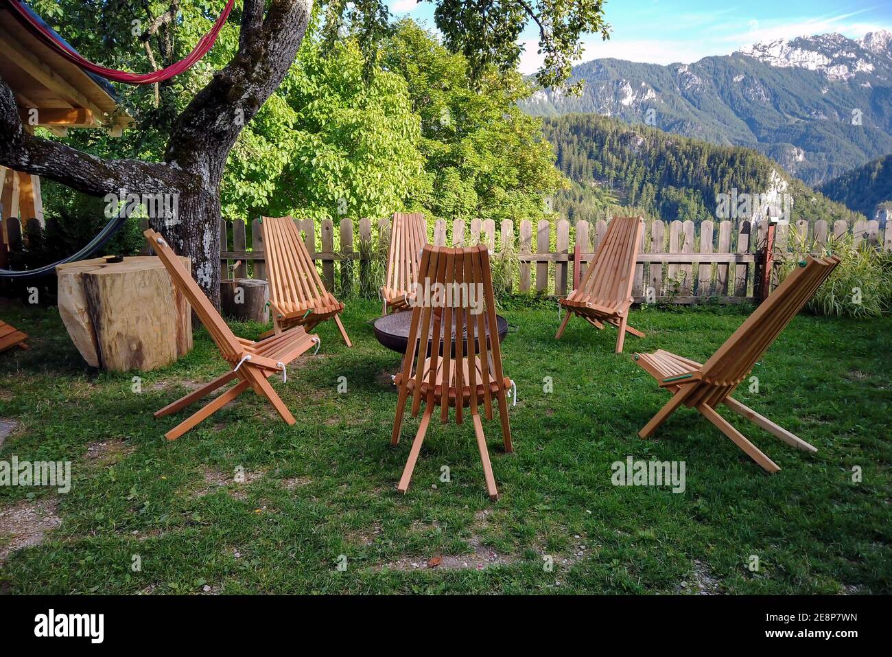 Salotto giardino con vista montagna, sedie a sdraio su terrazza rustica  sotto un albero Foto stock - Alamy