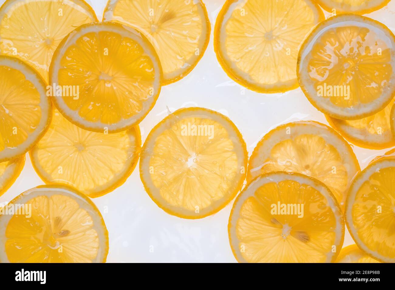 Fette di limone fresco sotto acqua fondo testurizzato. Foto Stock