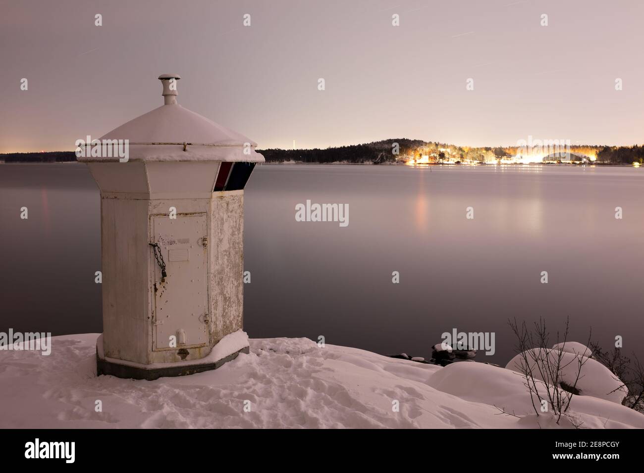 Faro bianco sulla costa di Bogesundslandet verso Lidingö, Svezia, vicino Stoccolma, durante una notte invernale Foto Stock