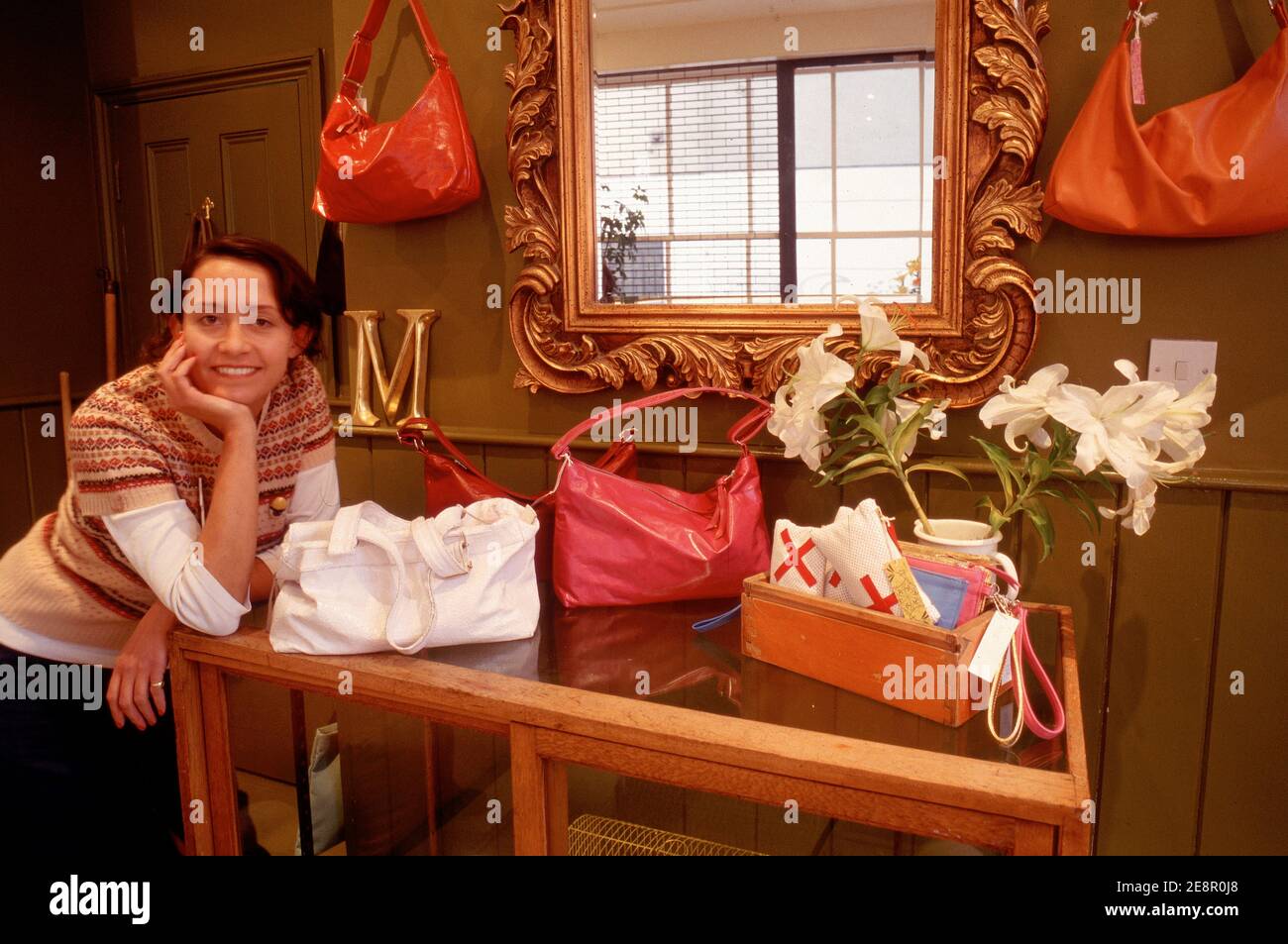 Proprietario nel suo negozio di borse a mano su Bricklane, Londra, Inghilterra Foto Stock