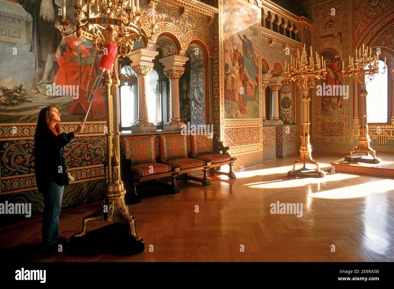 la donna è spolverata di lampadario d'oro al castello del re ludwig, schloss neuschwanenstein, baviera, germania Foto Stock