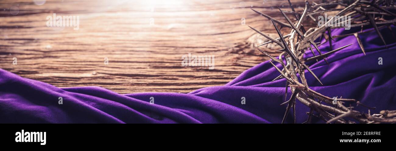 Corona di spine e Robe viola su pavimento in legno con Luce del sole - Crocifissione di Gesù Cristo Foto Stock