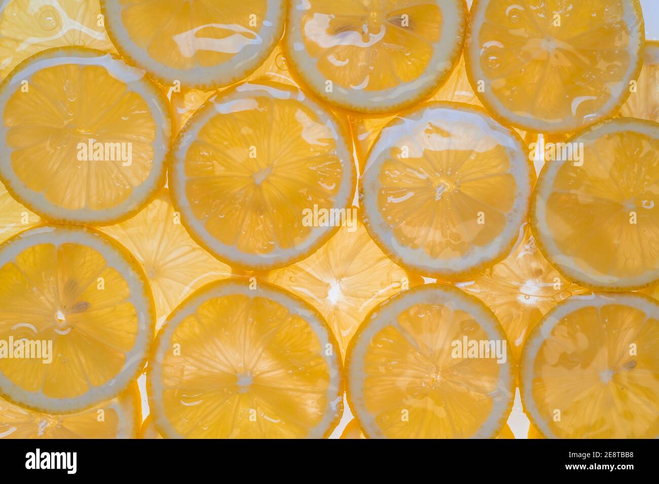 Fette di limone fresco sotto acqua fondo testurizzato. Foto Stock