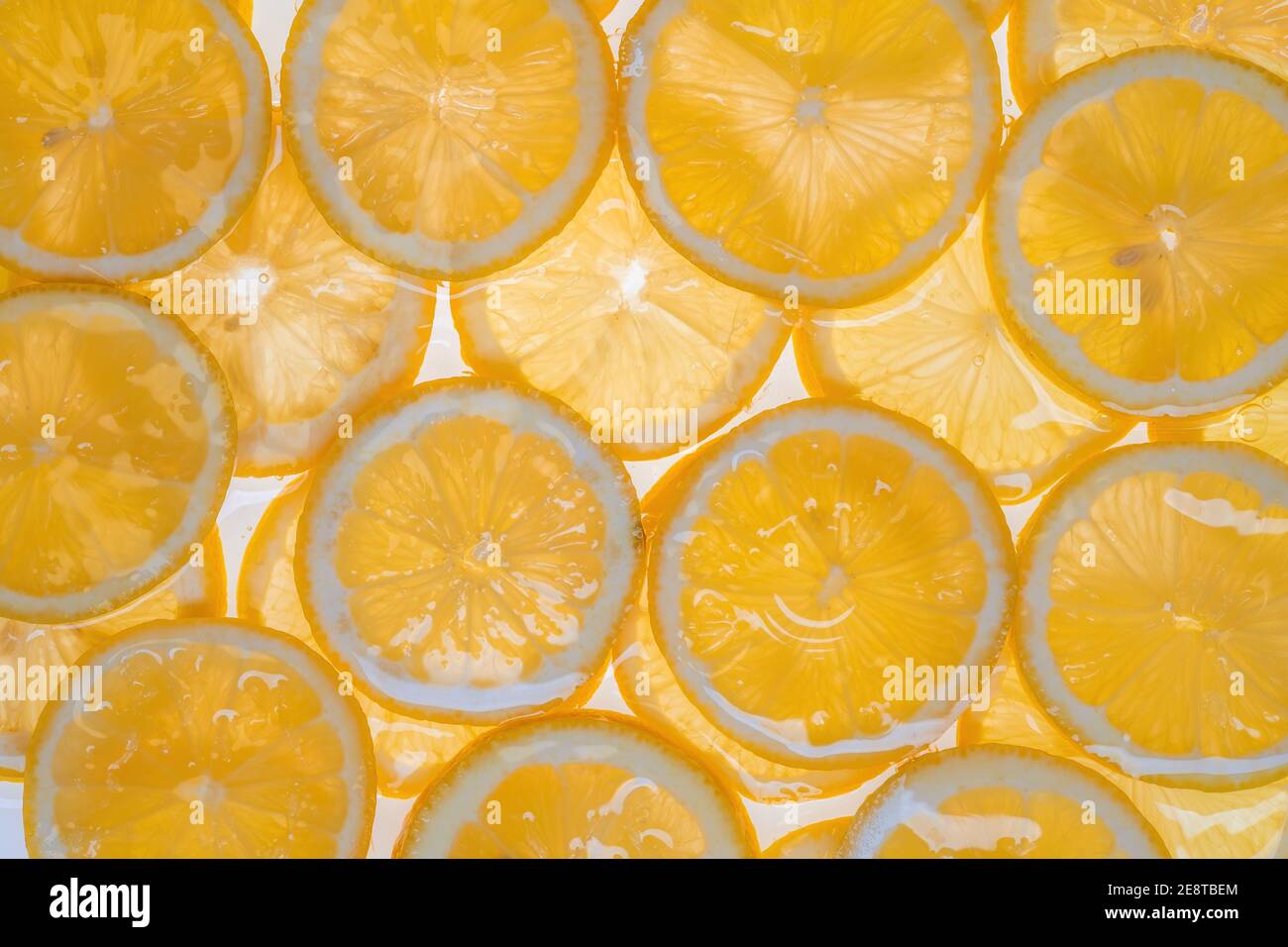 Fette di limone fresco sotto acqua fondo testurizzato. Foto Stock