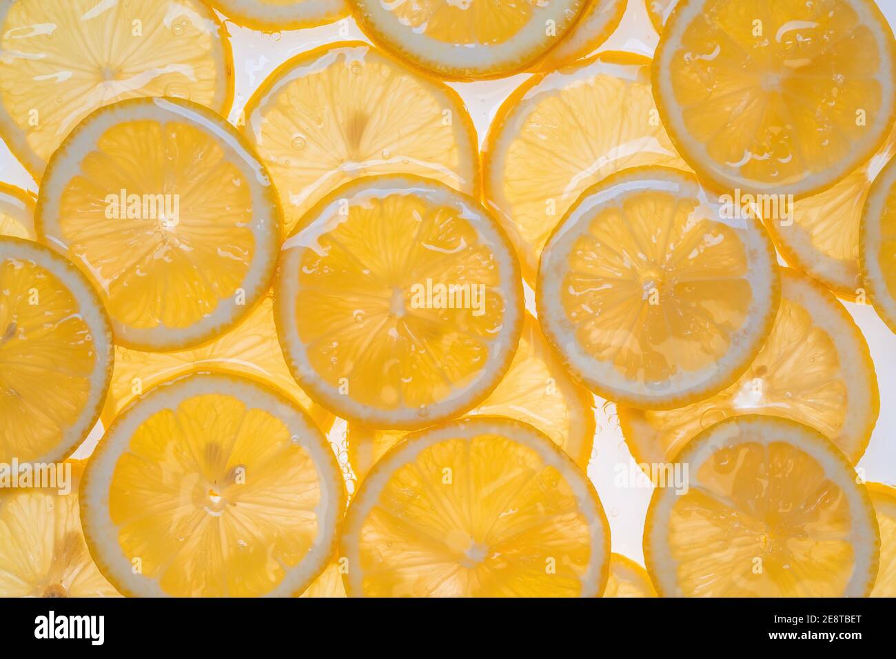 Fette di limone fresco sotto acqua fondo testurizzato. Foto Stock