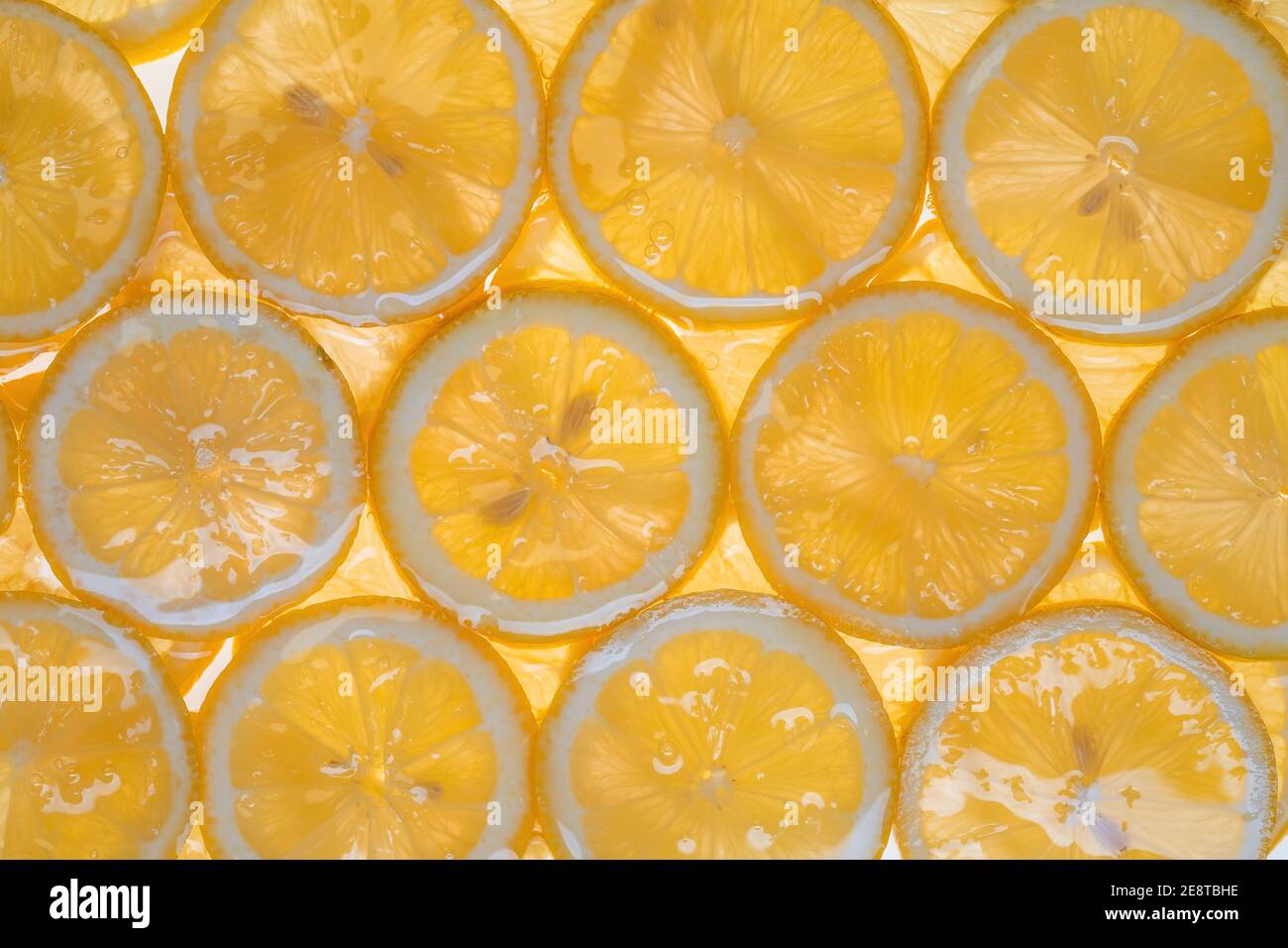 Fette di limone fresco sotto acqua fondo testurizzato. Foto Stock