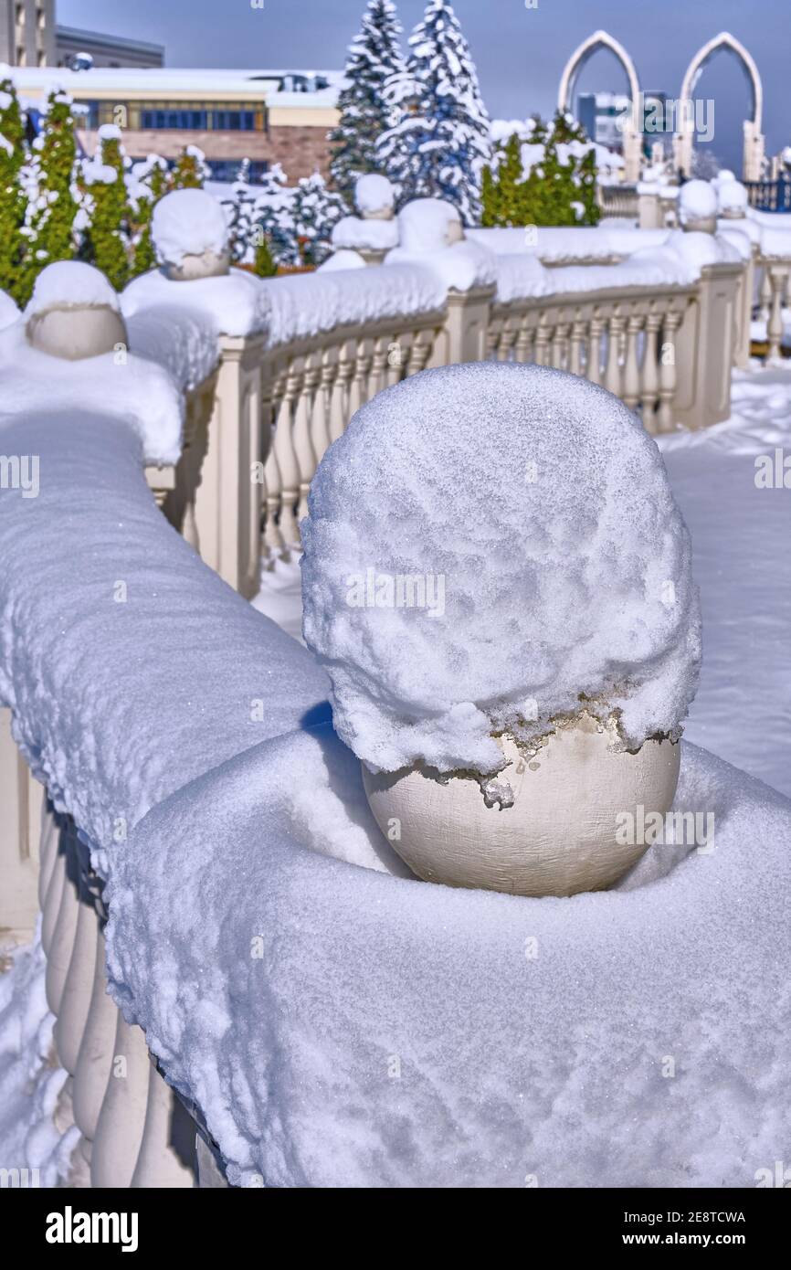 Neve fresca caduta sulla ringhiera decorativa nella stagione invernale; forme architettoniche moderne Foto Stock