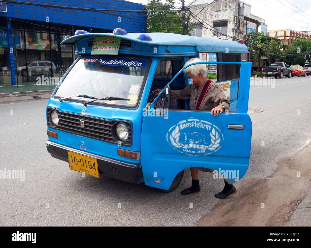 una donna anziana sta cercando di salire su una vecchia trasporti pubblici Foto Stock