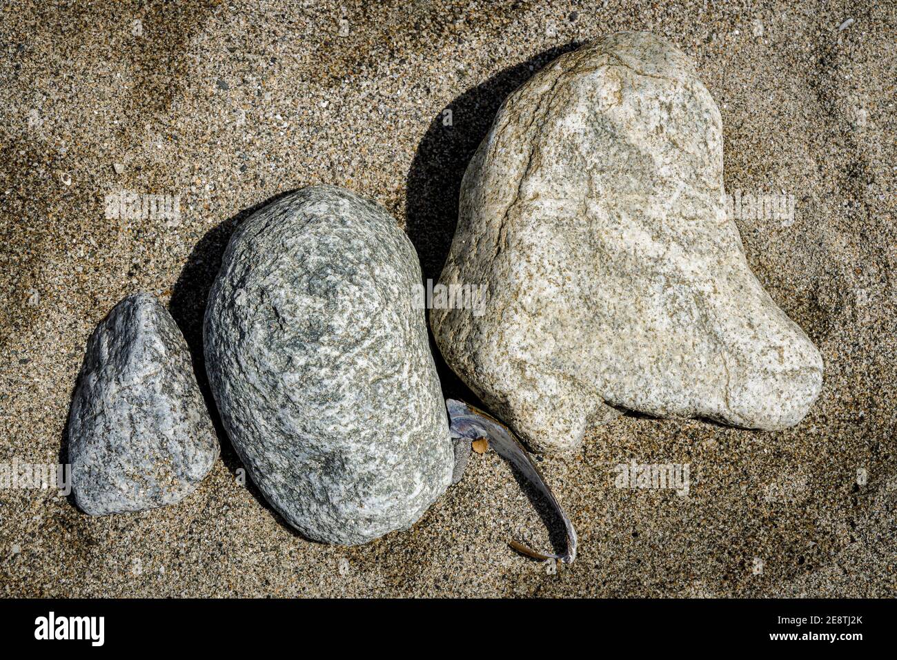 Tre rocce e pietre nella sabbia sulla spiaggia. Foto Stock