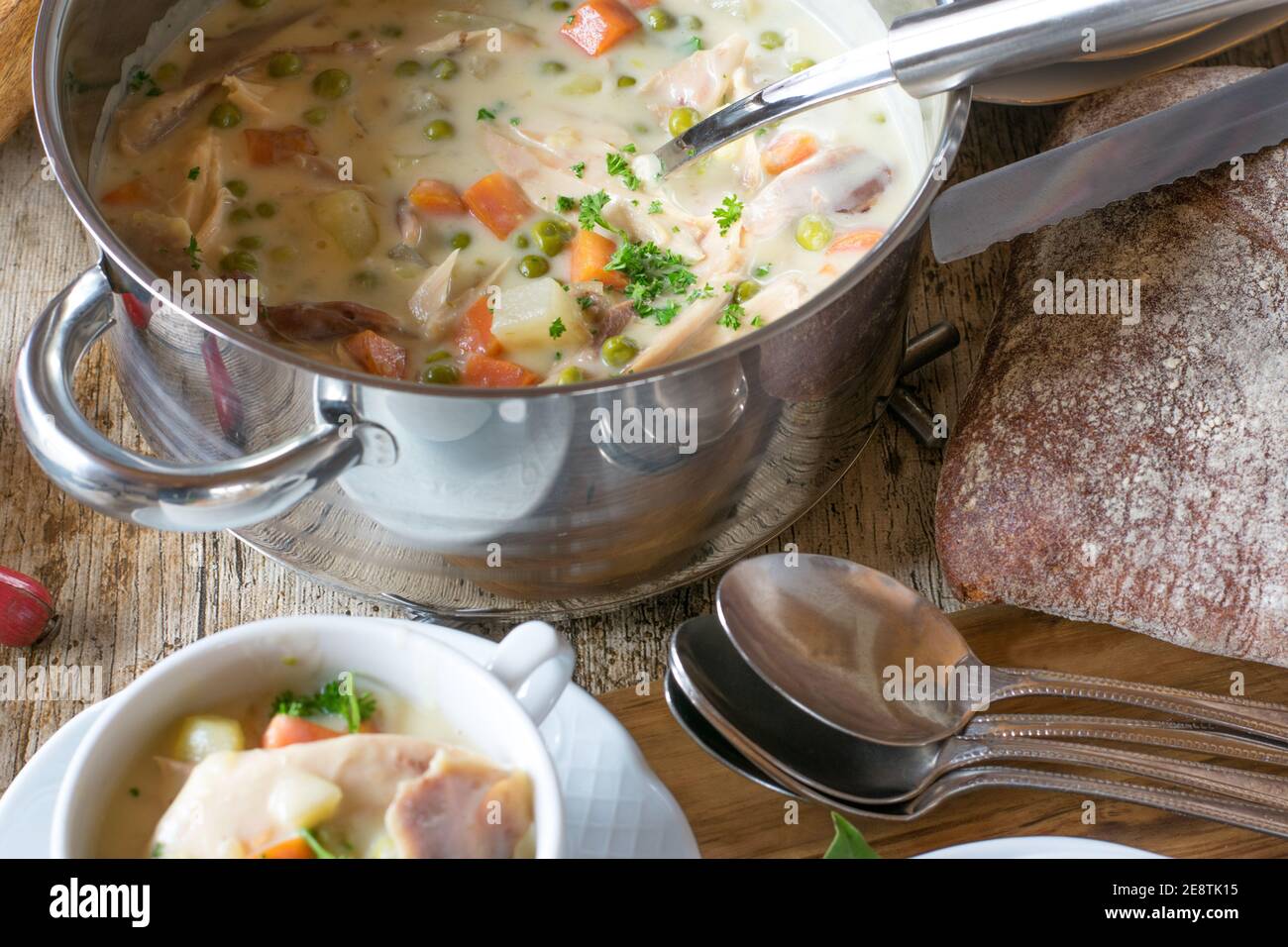 zuppa di pollo cremosa servita su un tavolo in una pentola con cucchiaio dall'alto Foto Stock