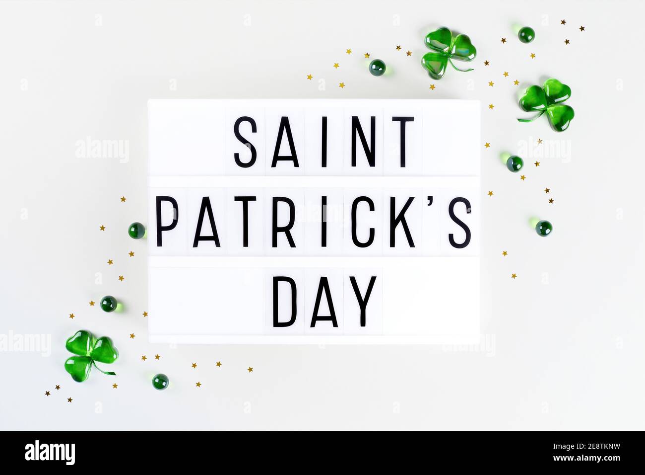 Scatola luminosa con testo di San Patrizio e sciamrocce di cuori di vetro verde Foto Stock