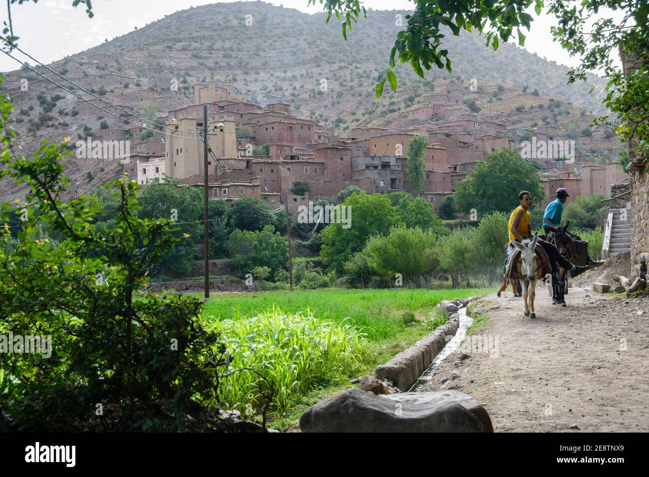 Due uomini che cavalcano un asino vicino al villaggio di Zaouiat Ahansa nelle montagne dell'Alto Atlante del Marocco, noto per i suoi altiri (granai collettivi)l Foto Stock