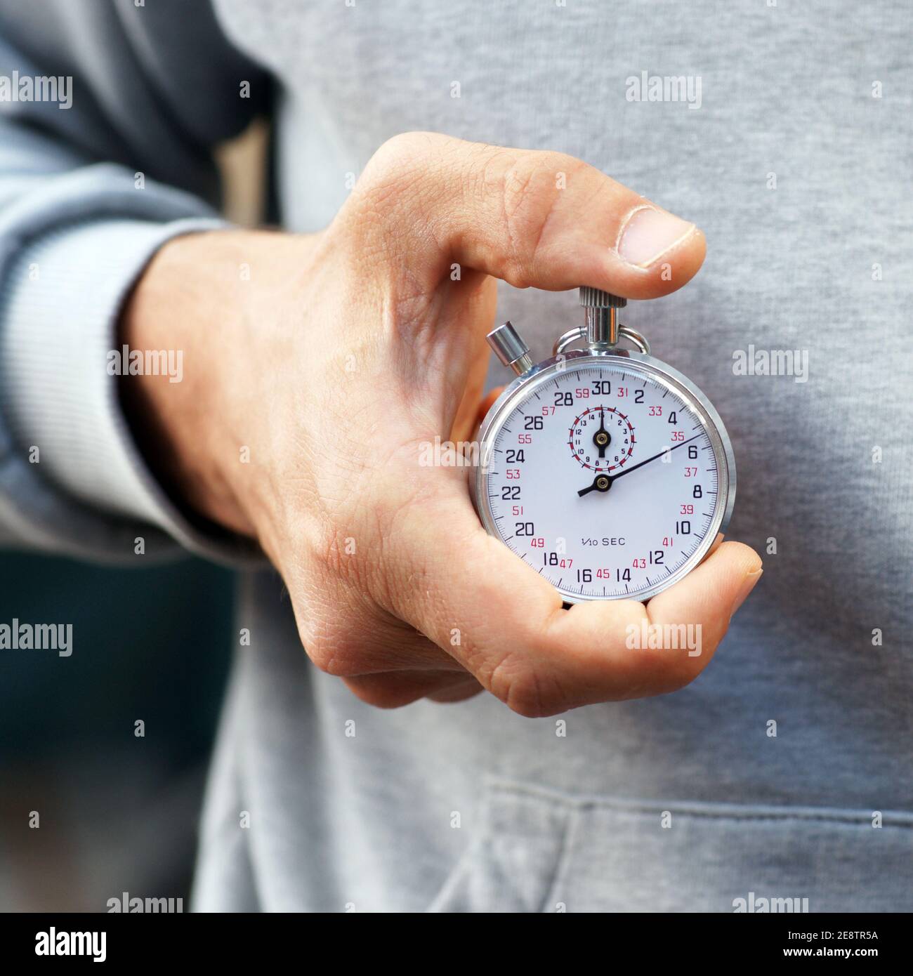 L istruttore tiene il cronometro in mano e preme START e. Pulsante Stop primo piano Foto stock Alamy