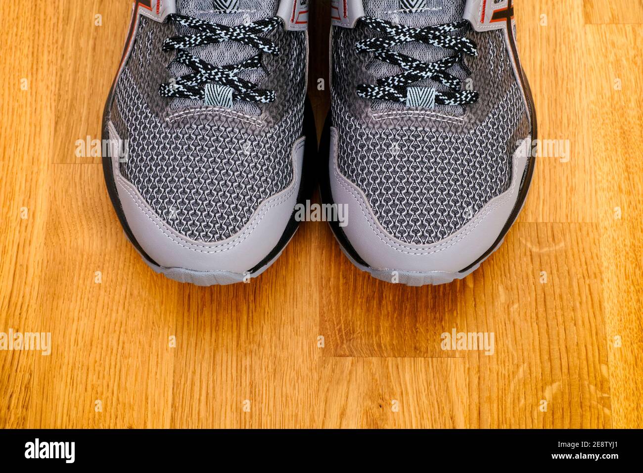 Nuove scarpe da running grigie su fondo parquet Foto stock - Alamy